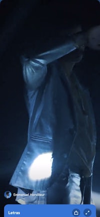 a man in a jacket is holding a flashlight in the dark