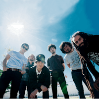 a group of people posing in front of the sun