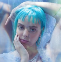 a woman with blue hair is posing for a photo